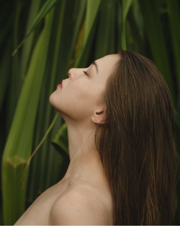 Viso di giovane donna che si applica olio viso beauty caress di vilo cosmetics