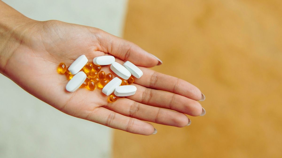 mano di giovane donna con integratori