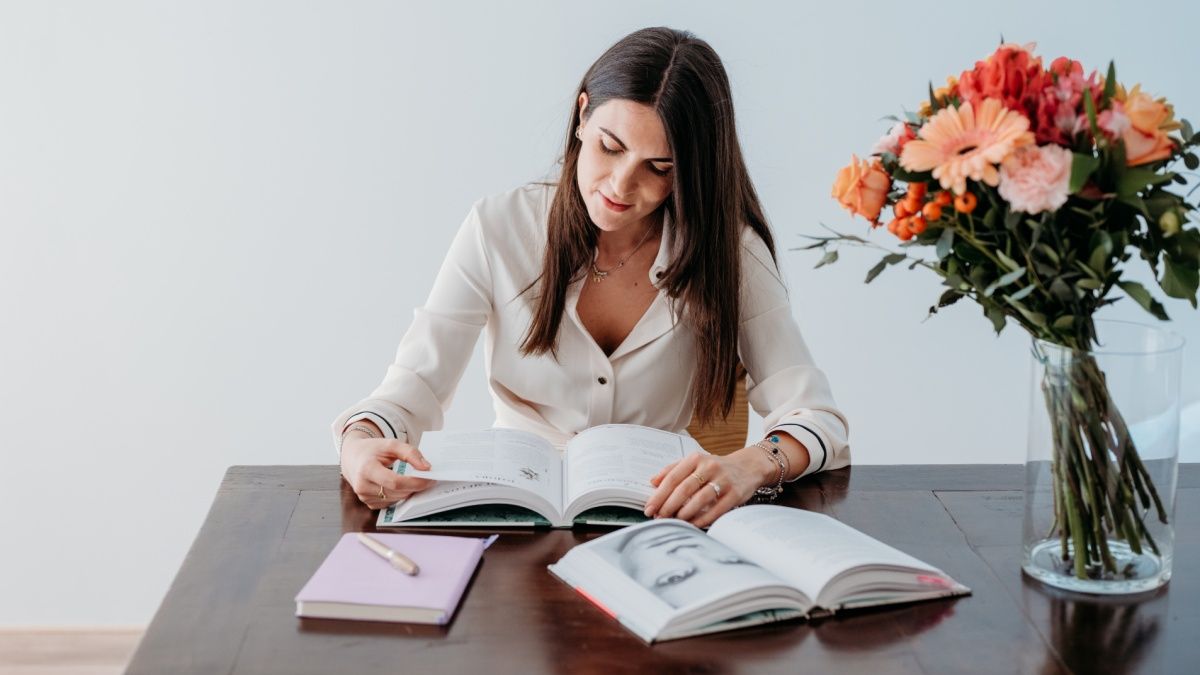 Foto della dottoressa Vittoria Lonetti che sfoglia un'enciclopedia erboristica