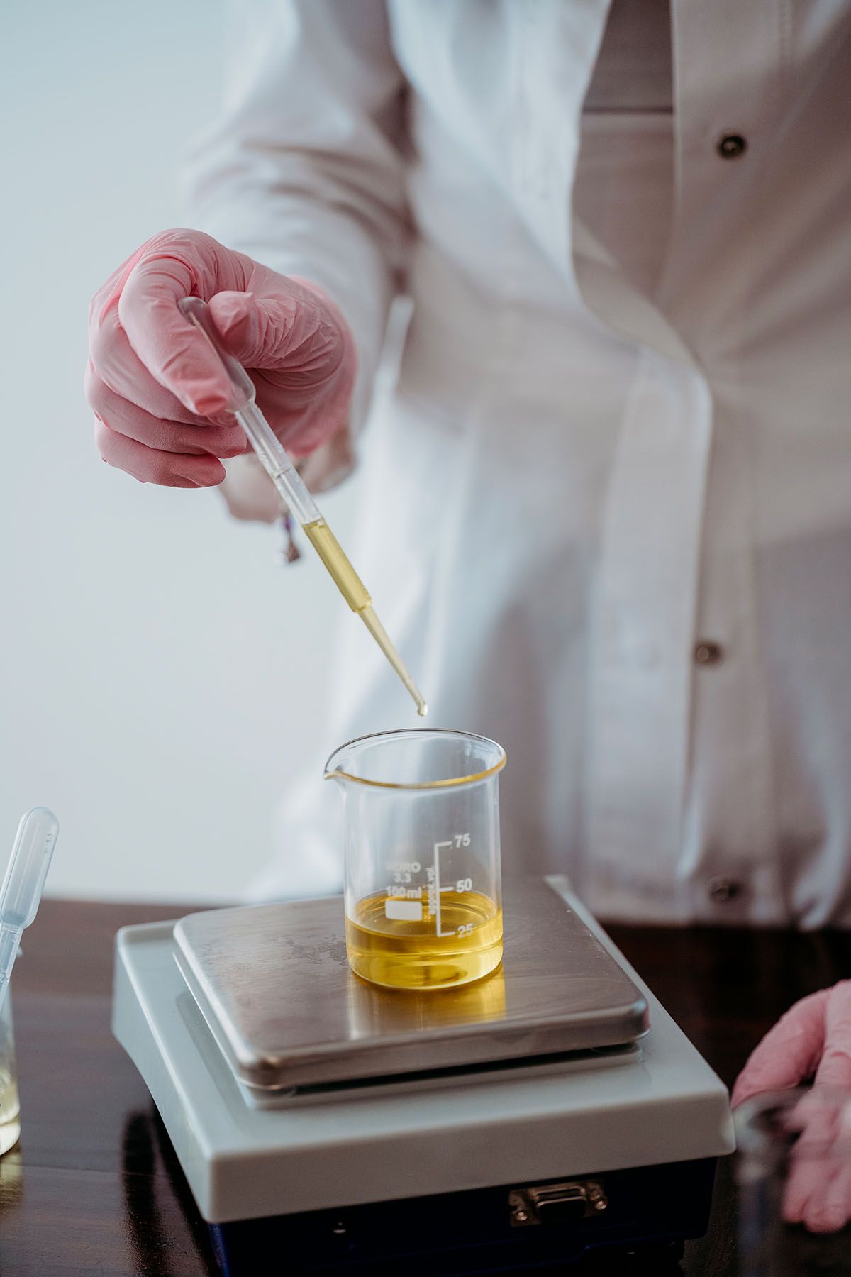 Foto della dottoressa Vittoria Lonetti in laboratorio mentre usa la bilancia per pesare uno dei preziosi oli naturali