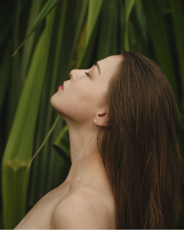 Viso di giovane donna che si applica olio viso beauty caress di vilo cosmetics